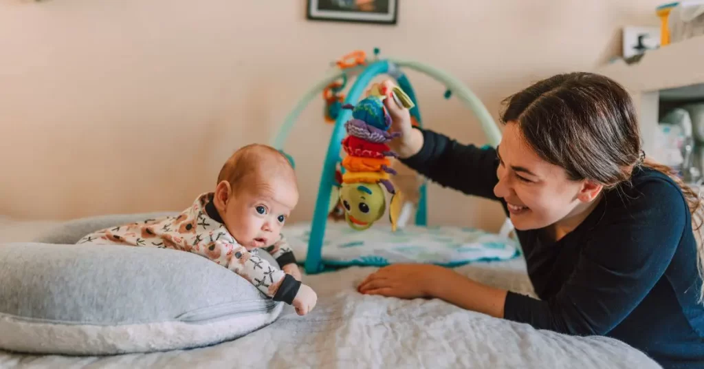 Mom holding up a toy in front of baby trying to teach baby sign language