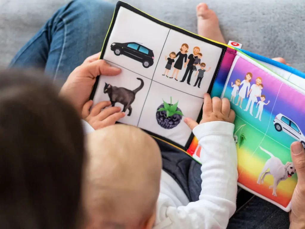 Baby sitting in parent's lap reading a book 