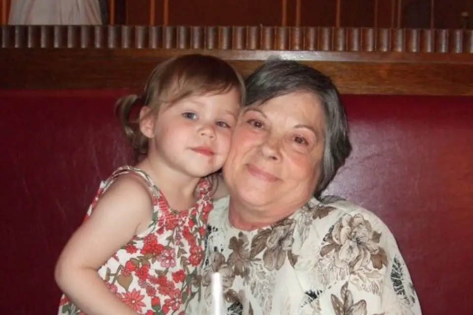 Young child and grandma smiling cheek to cheek posing for a picture