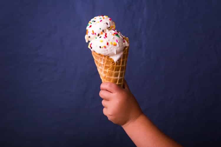 child's hand holding an Ice cream cone