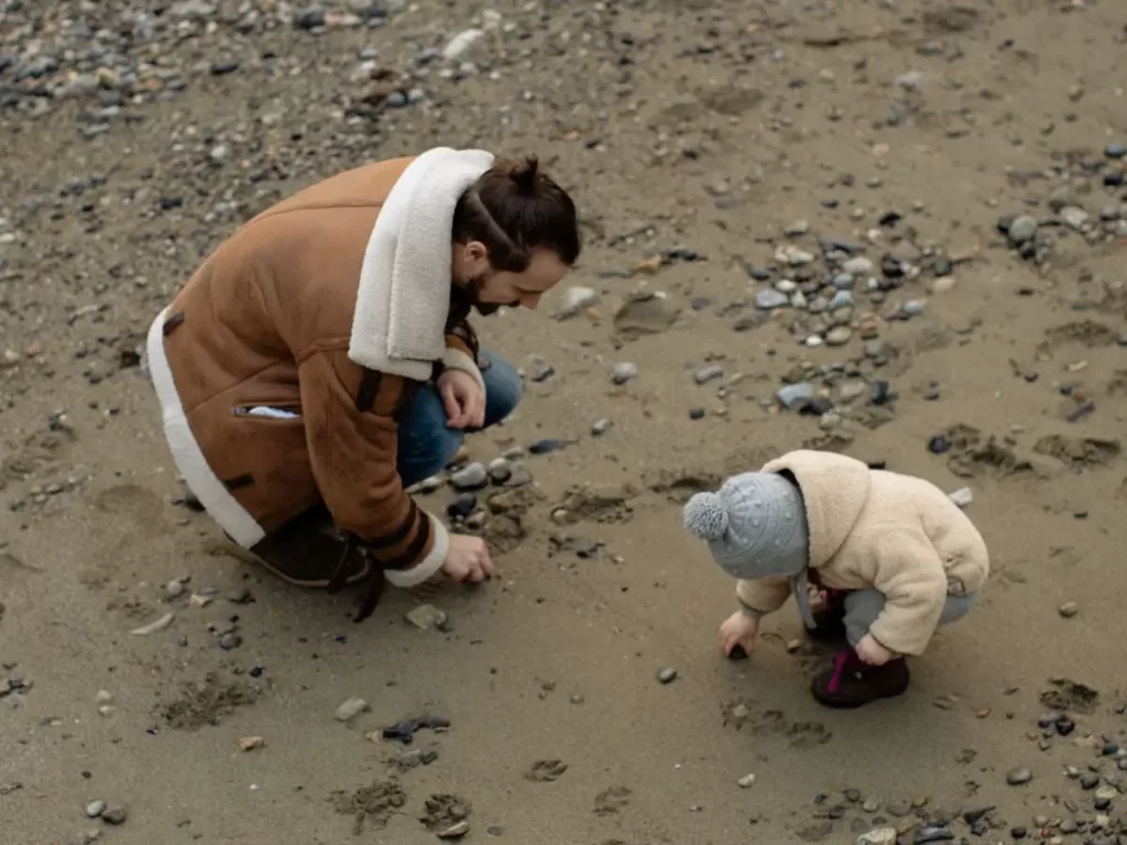 Dad and child exploring on the beach