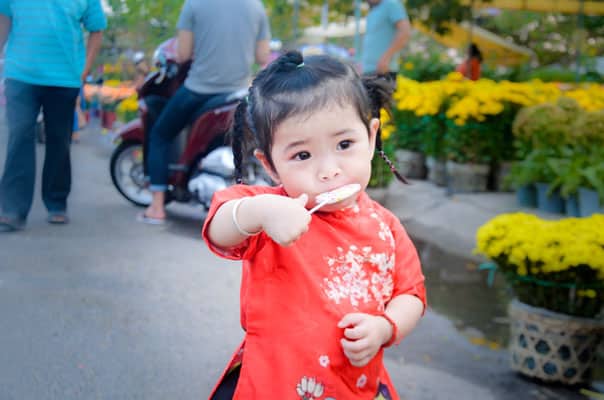 Little girl eating a popsicle in a red shirt