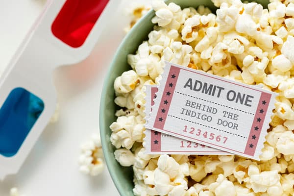 picture of movie tickets in a bowl of popcorn with 3d glasses beside