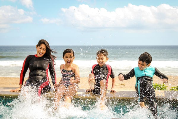 Mom with kids splashing at a pool