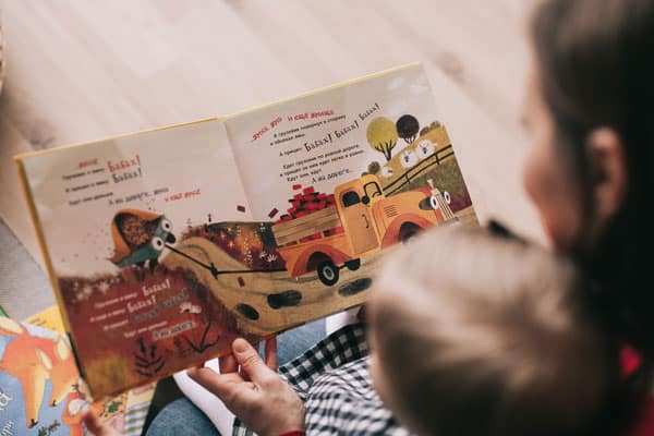 mom reading a book to child.