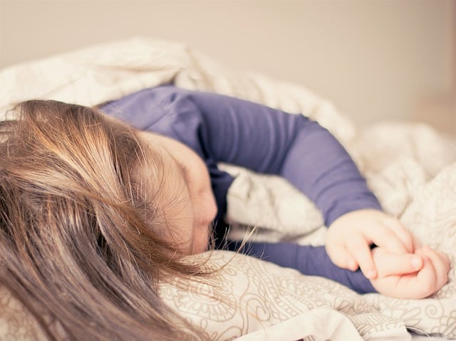 A child following an early bedtime schedule before school starts.