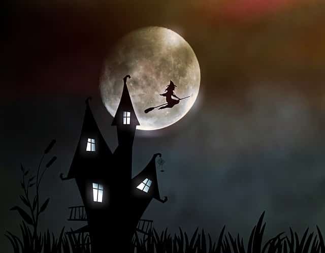 Haunted house with a witch flying in front of a moon
