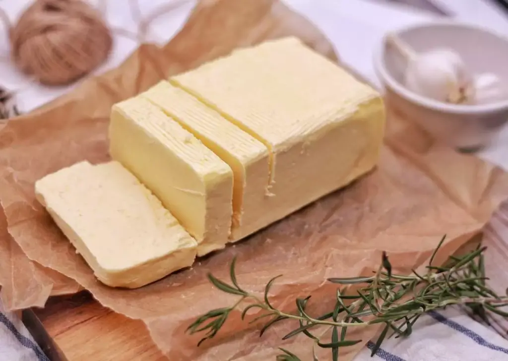 a bar of butter sliced and kept on parchment paper