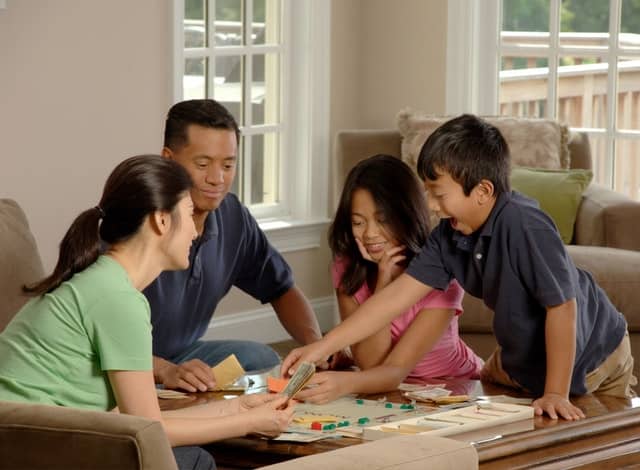 Family playing games together around a table for family game night