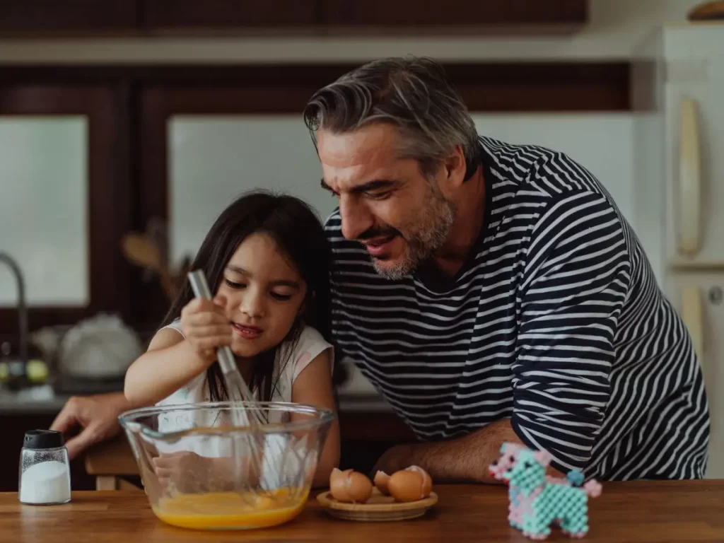 daughter cooking eggs with dad in the kitchen on Father's day