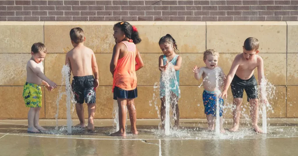 children cooling off this summer while playing in a fountain