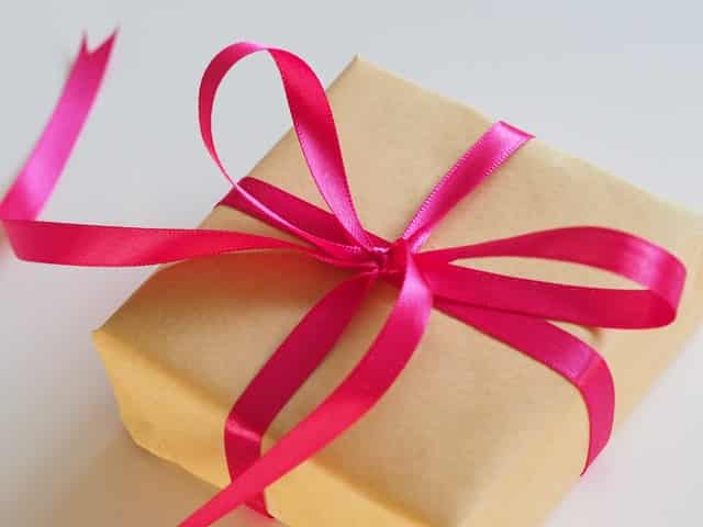 gift wrapped in brown paper and tied with pink ribbon