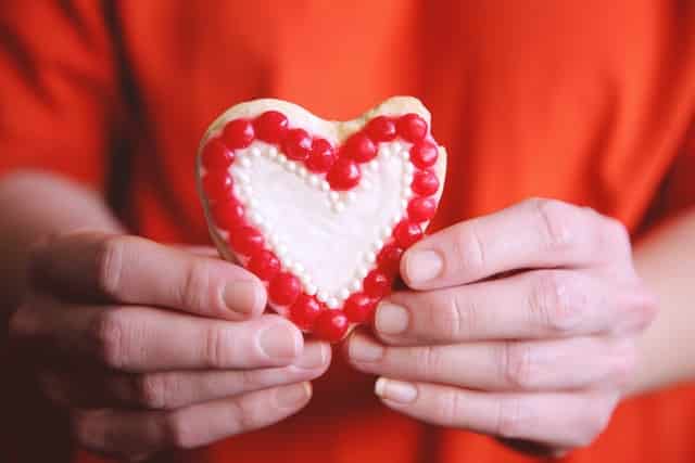A child holding a heart shaped cookie