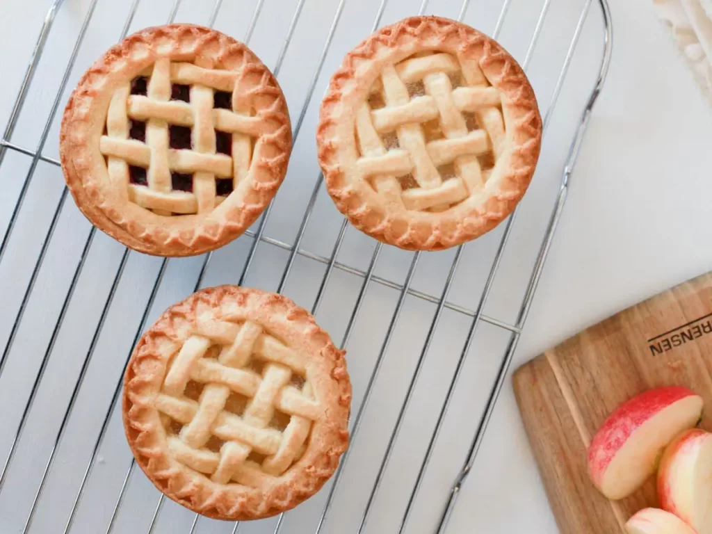 three mini pies cooling on a rack