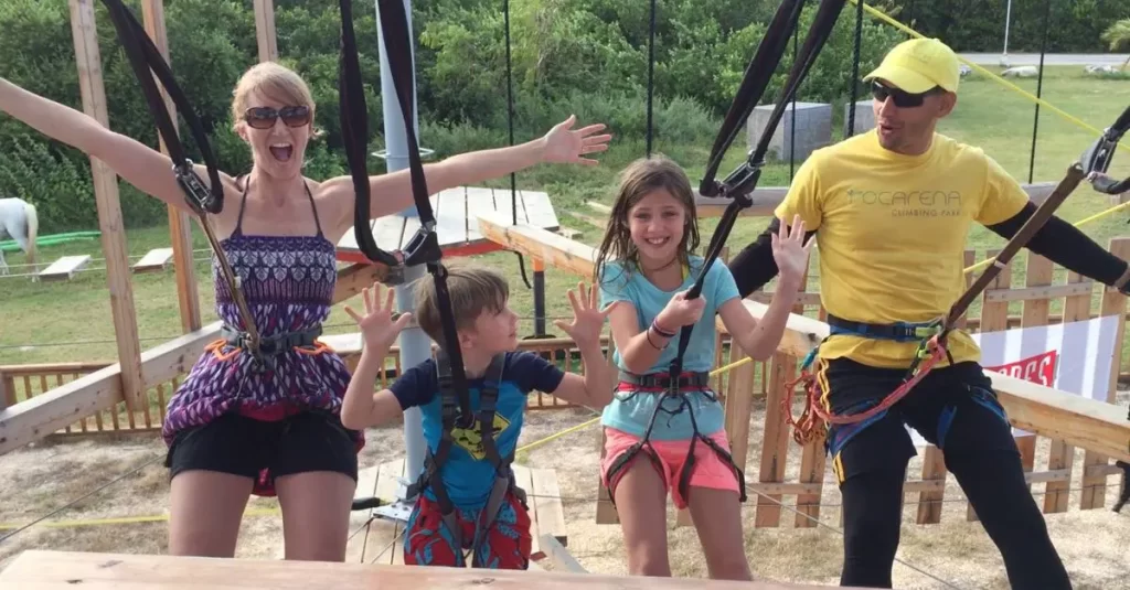 Mom and kids posing for picture of a rope course. Solo parent travel