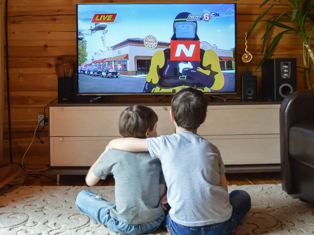 kids sitting on the floor watching television