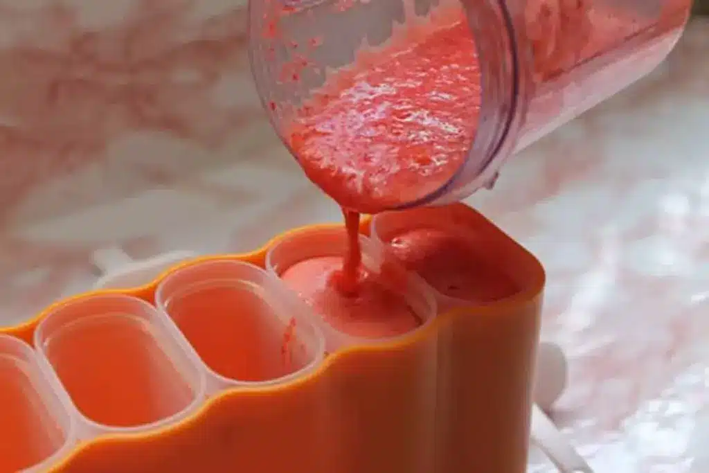 ingredients being poured into popsicle mold